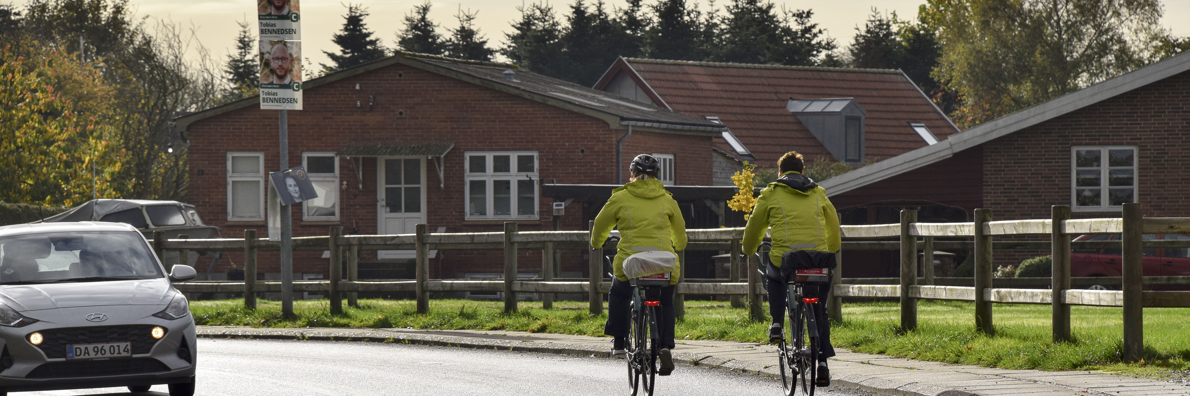 To cykelister med ens jakker på en vej