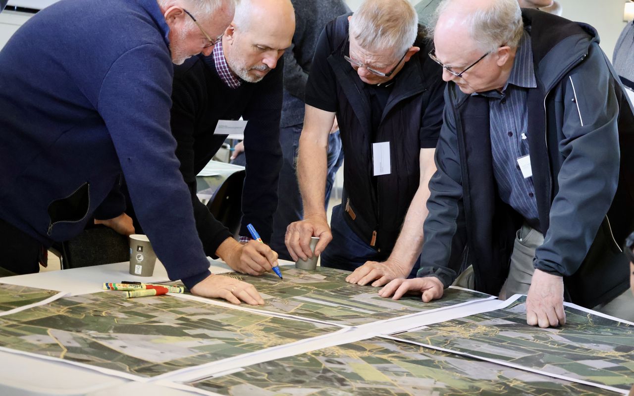 Lodsejere og formand for treparten kigger på matrikelkort