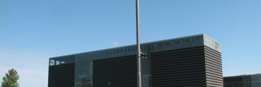 Stor sort bygning med en lang skorsten. Svendborg Kraftvarme.