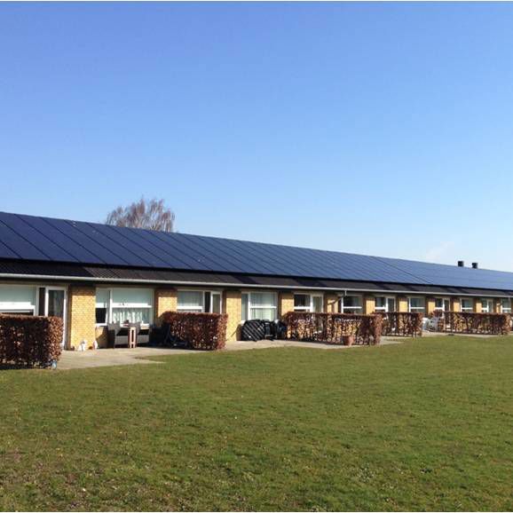 En bygning bestående af rækkehuse med solceller på taget