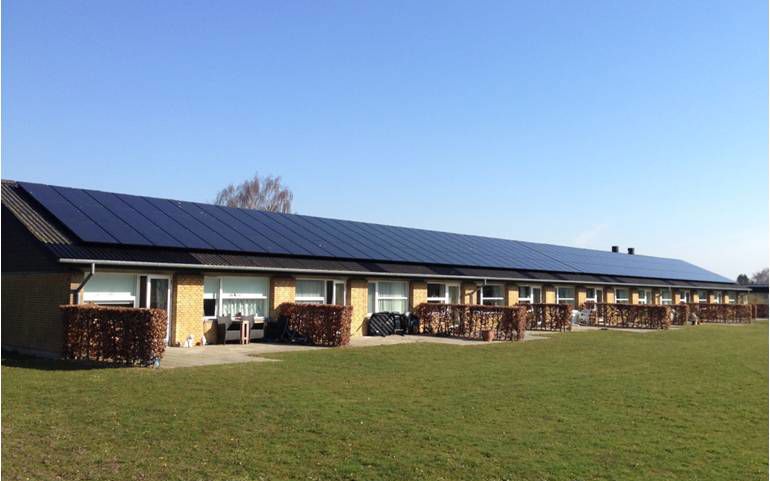 En bygning bestående af rækkehuse med solceller på taget