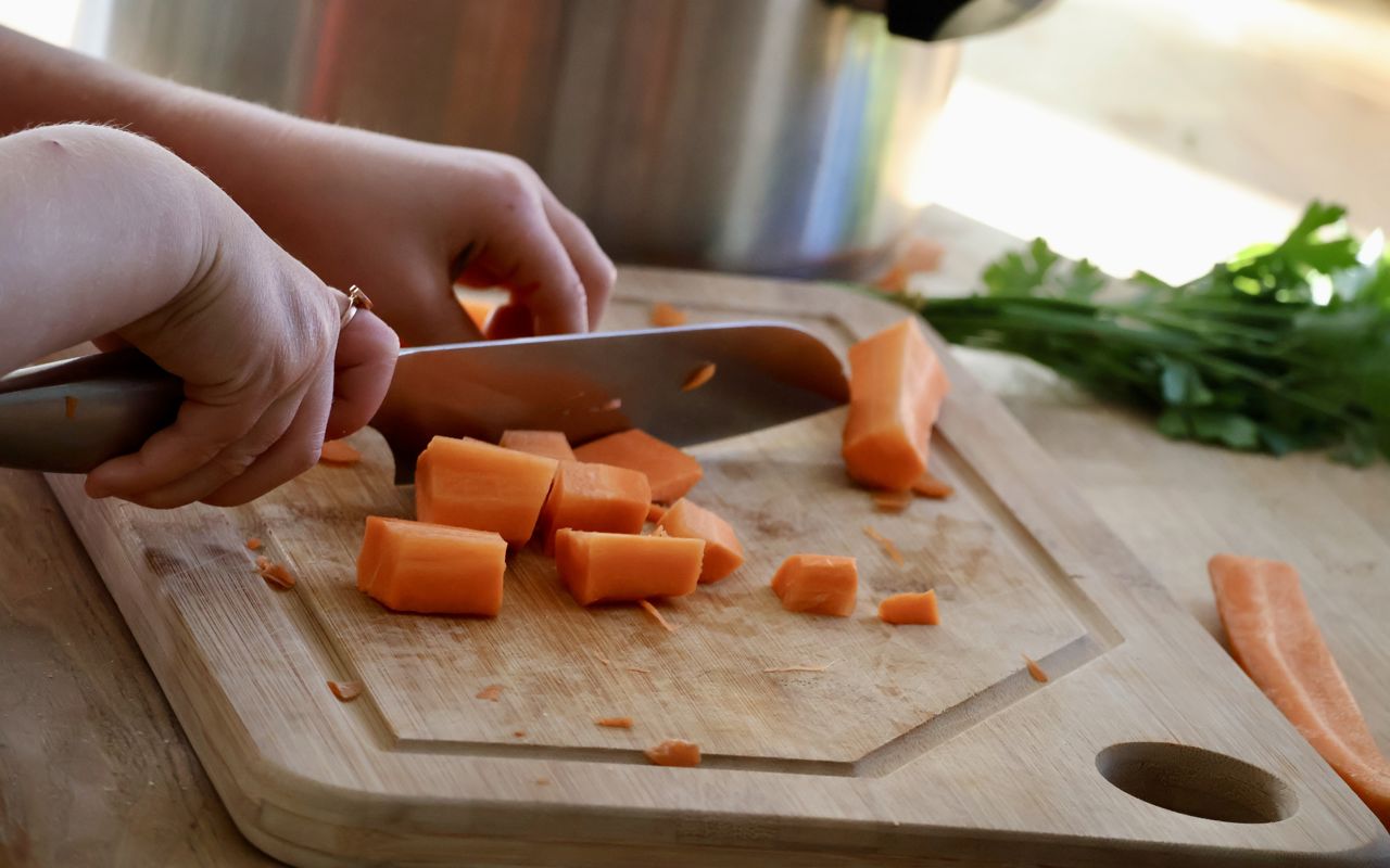 Barn, der er i gang med at skære gulerødder.