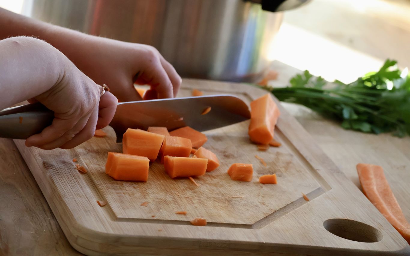 Barn, der er i gang med at skære gulerødder.