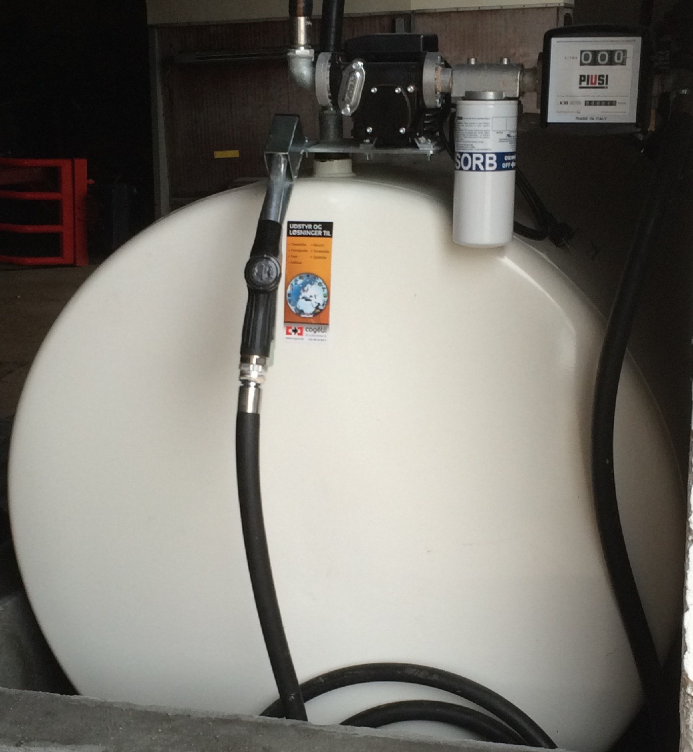 Hvid olietank set fra enden med slangen