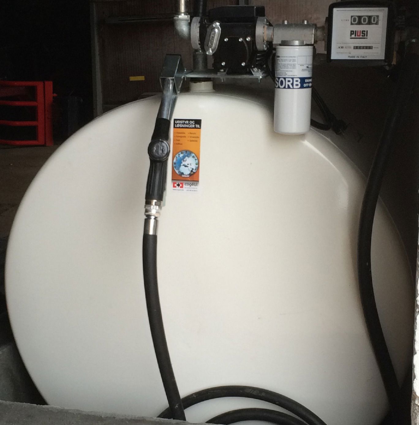 Hvid olietank set fra enden med slangen