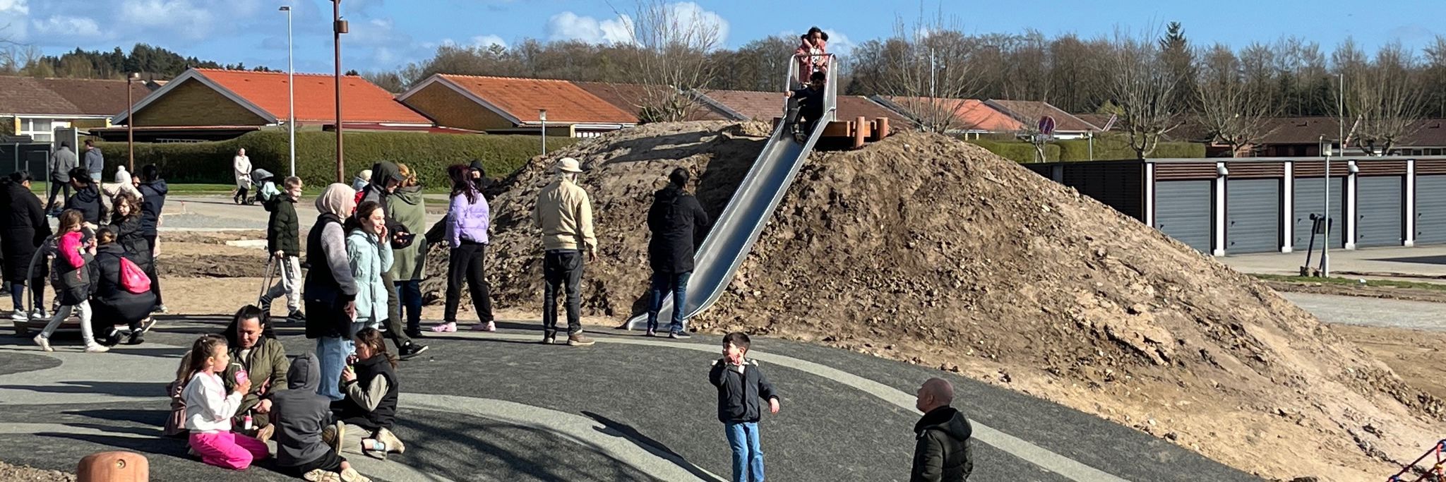 Børn rutcher ned af en stålrutchebane