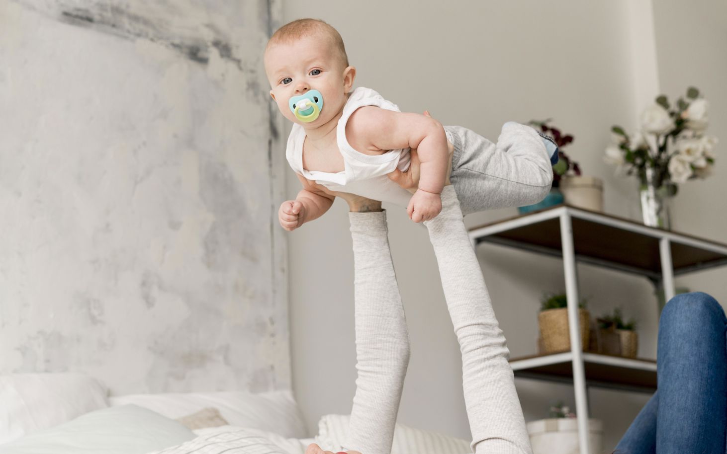 Kvinde løfter baby op i luften