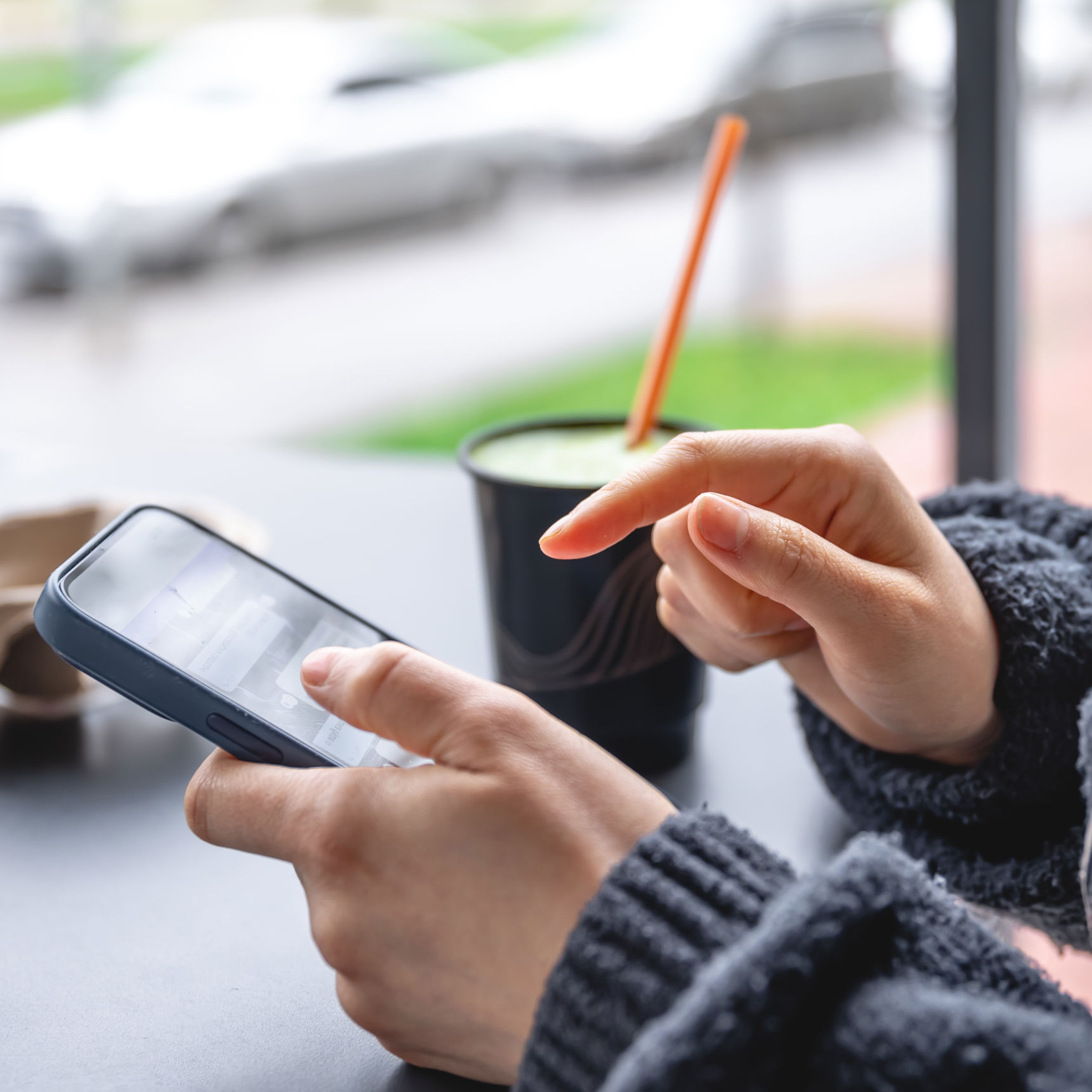 Kvinde siddder med mobil i hånden