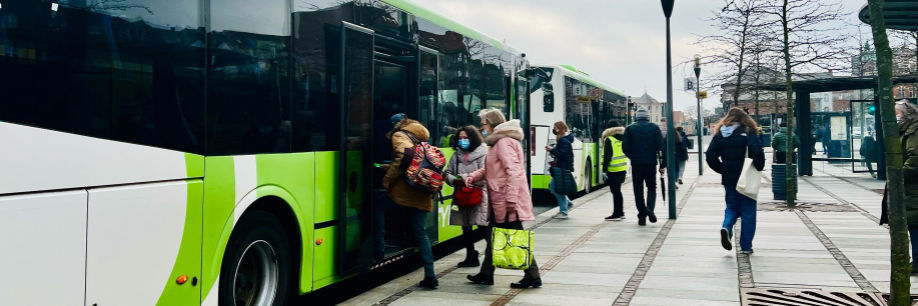 Mange mennesker er på vej ind i to busser, der holder foran et fortov. Svendborg Busterminal.