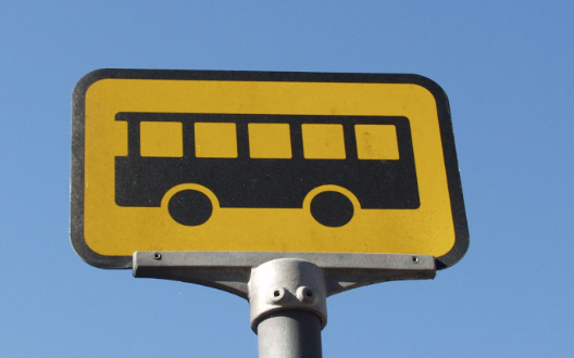Et gult skilt med et ikon af en sort bus.