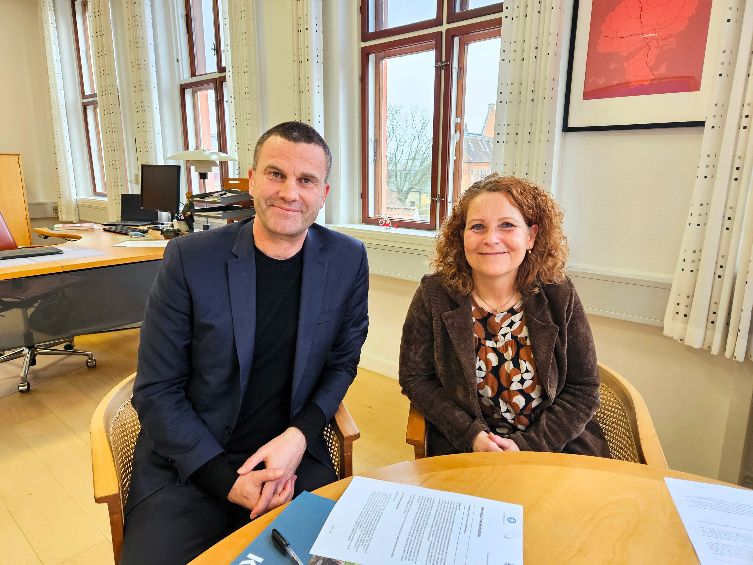 Borgmester Bo Hansen og Provst Bente Holdgaard har netop underskrevet en klimapartnerskabsaftale. De smiler til kameraet.