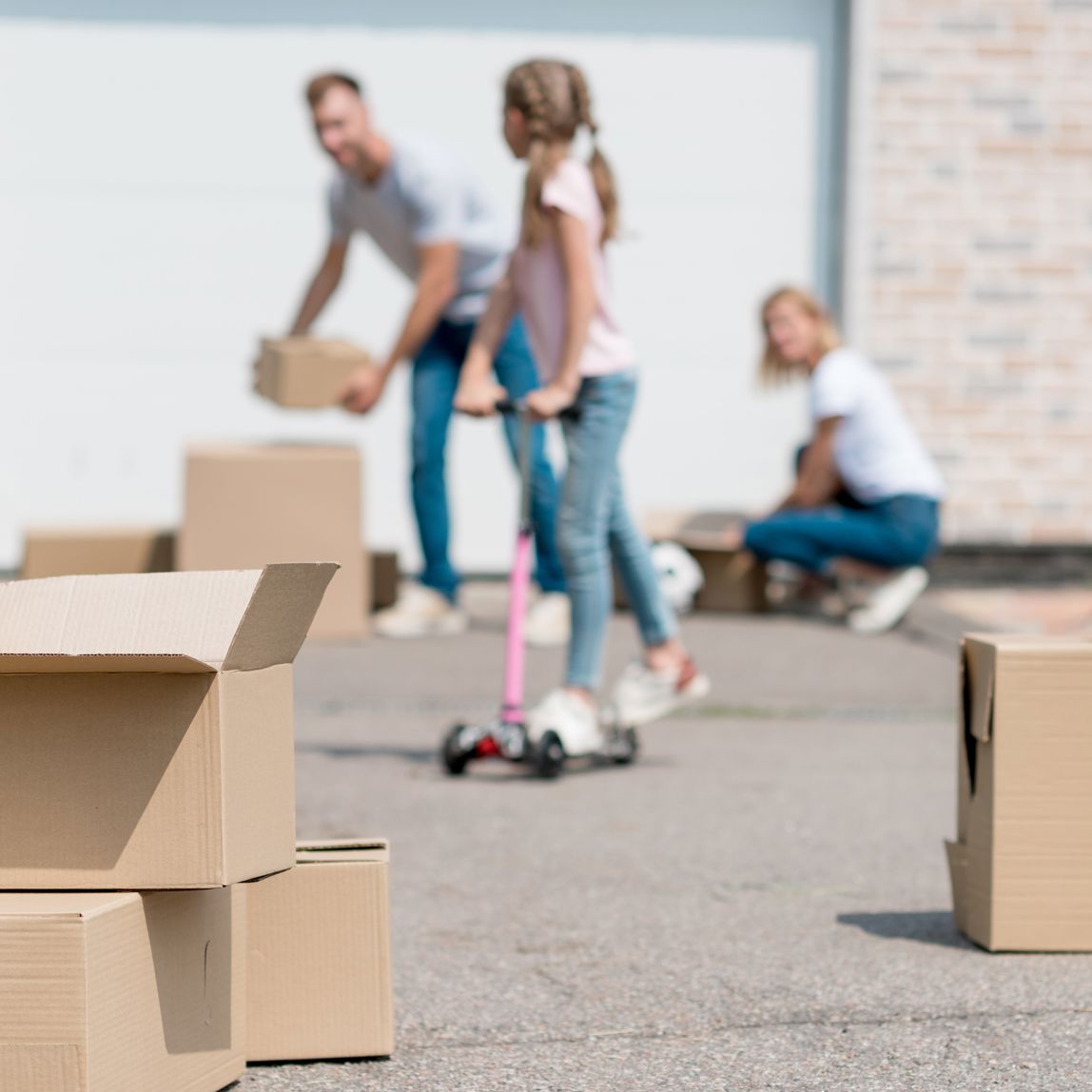 Familie med flyttekasser i indkørsel