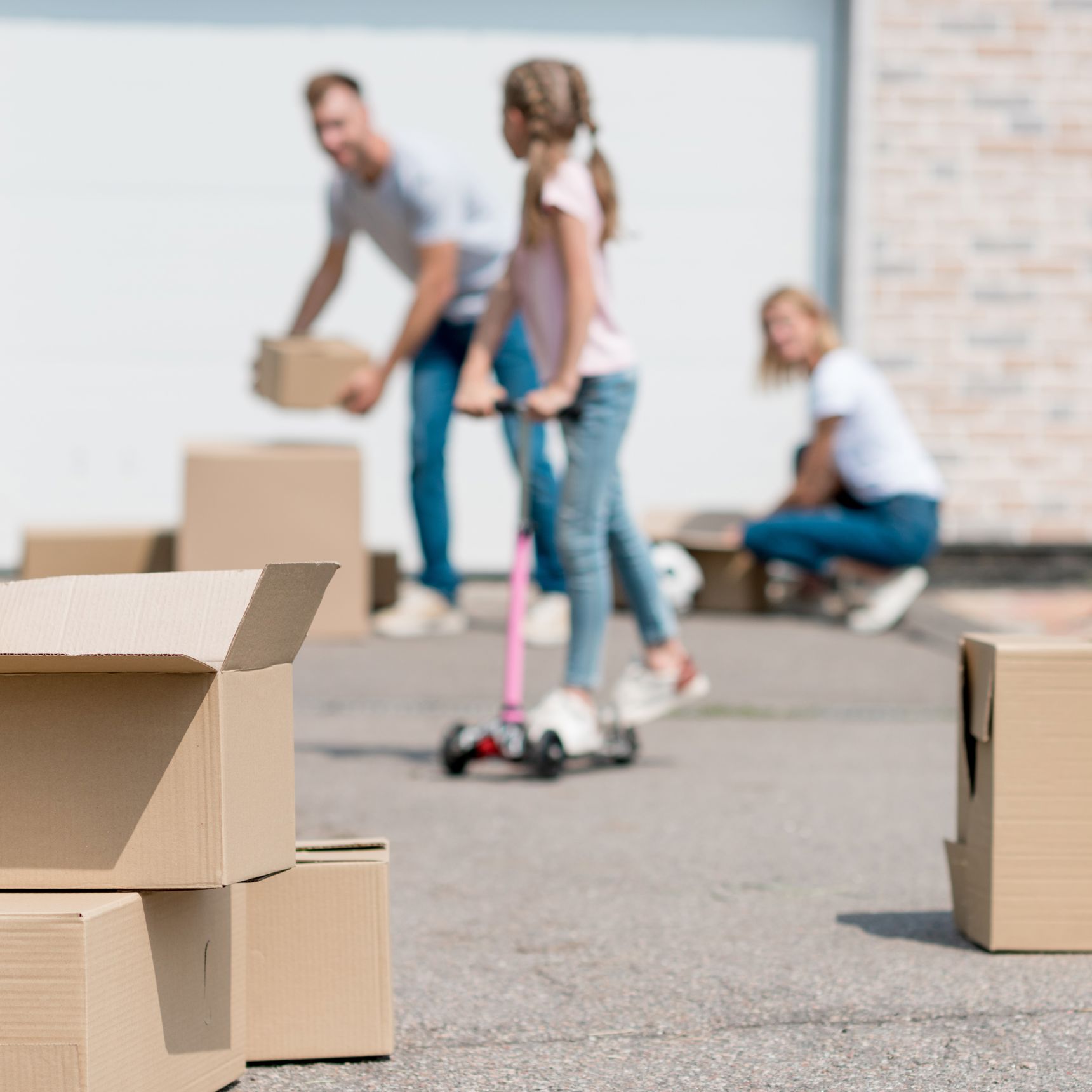 Familie med flyttekasser i indkørsel