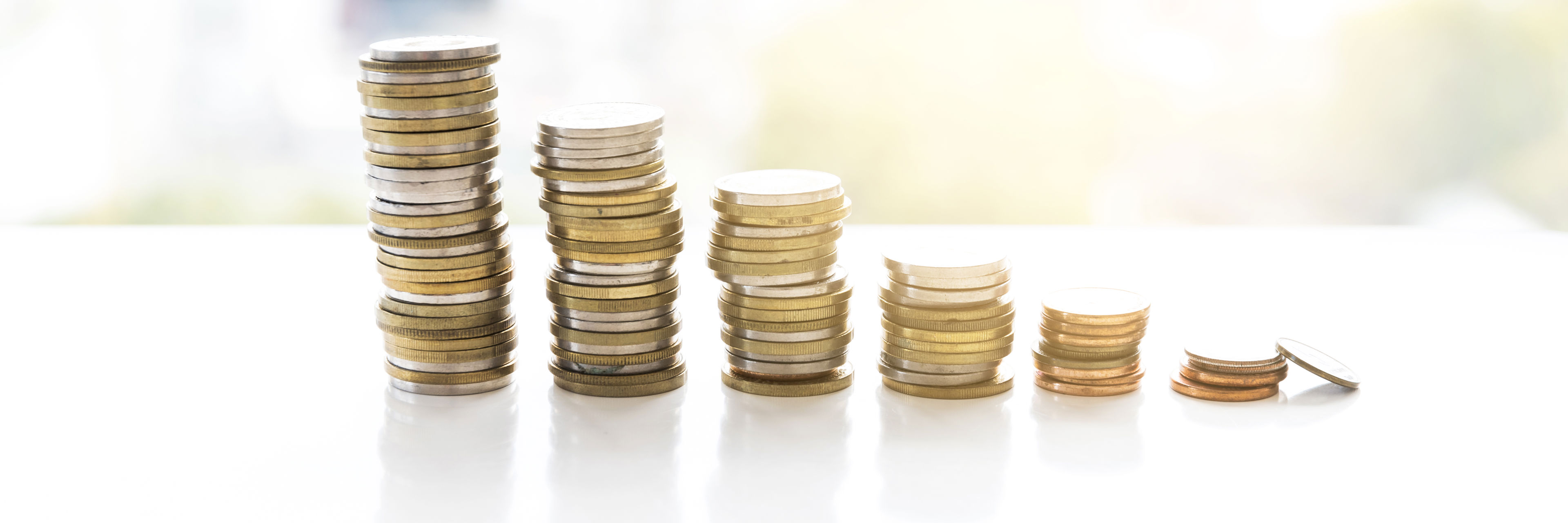 Mønter stabler i seks tårne. Tårnet til venstre er højest. De efterfølgende tårne bliver mindre og mindre.