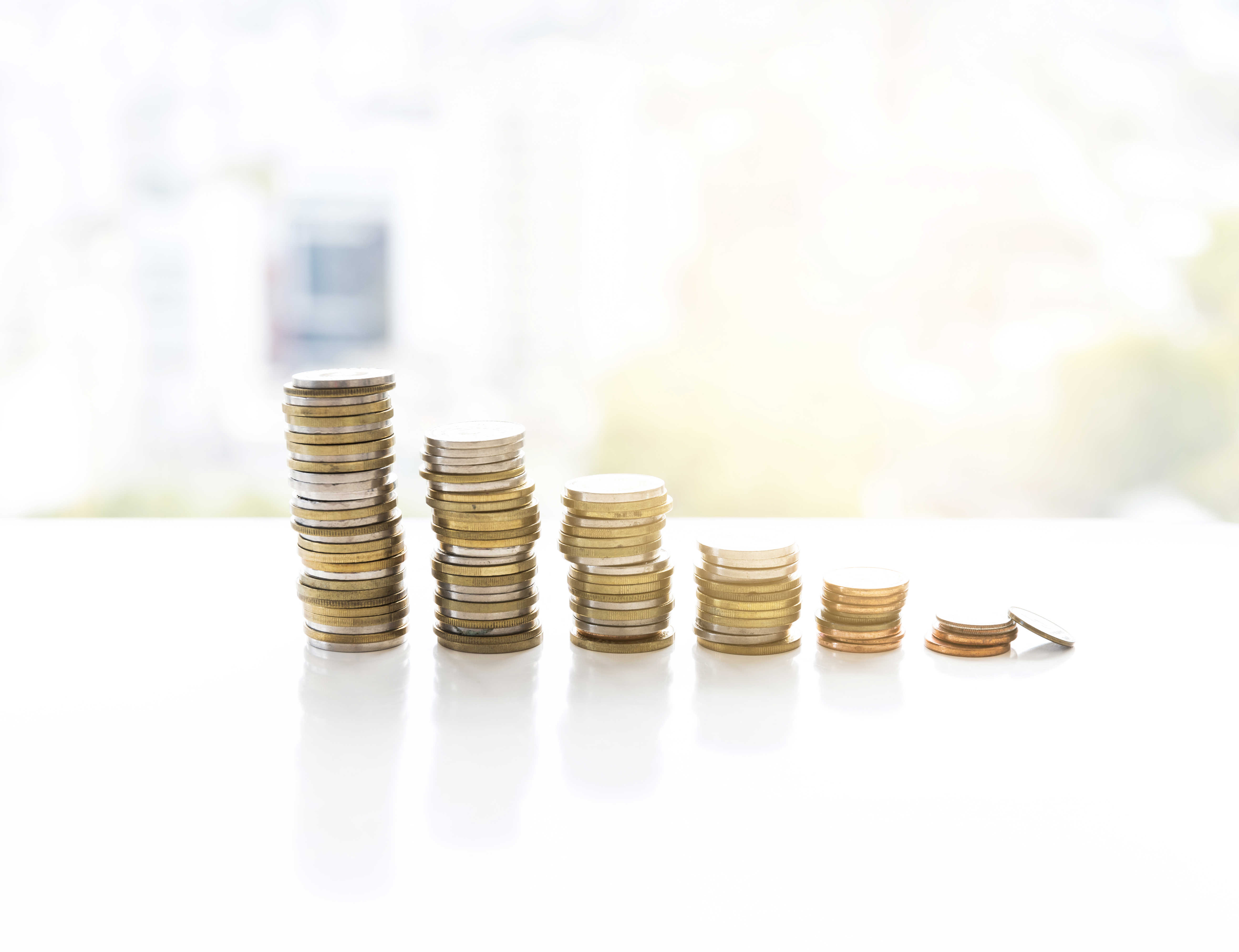 Mønter stabler i seks tårne. Tårnet til venstre er højest. De efterfølgende tårne bliver mindre og mindre.