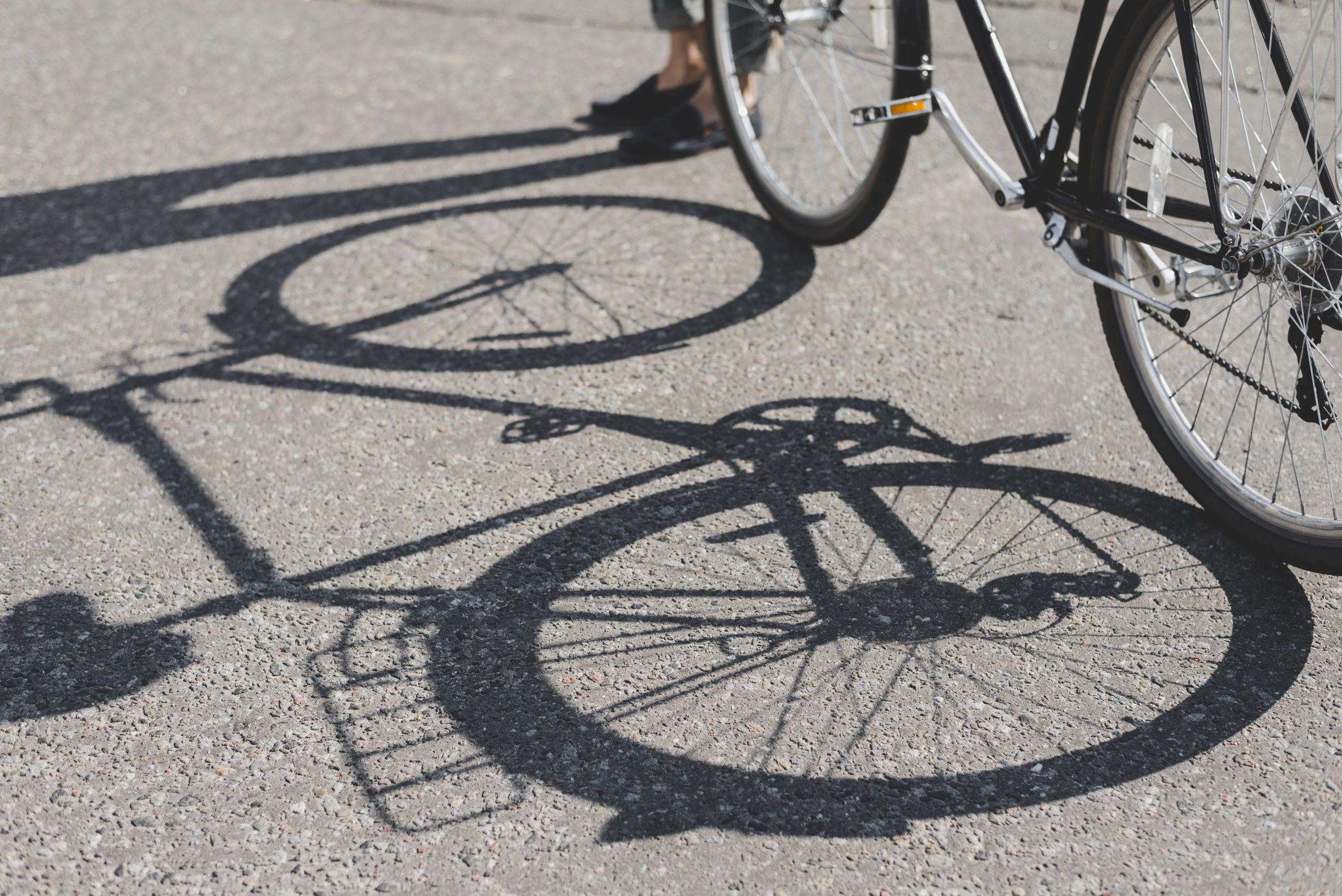 Skyggen af en cykel i asfalt