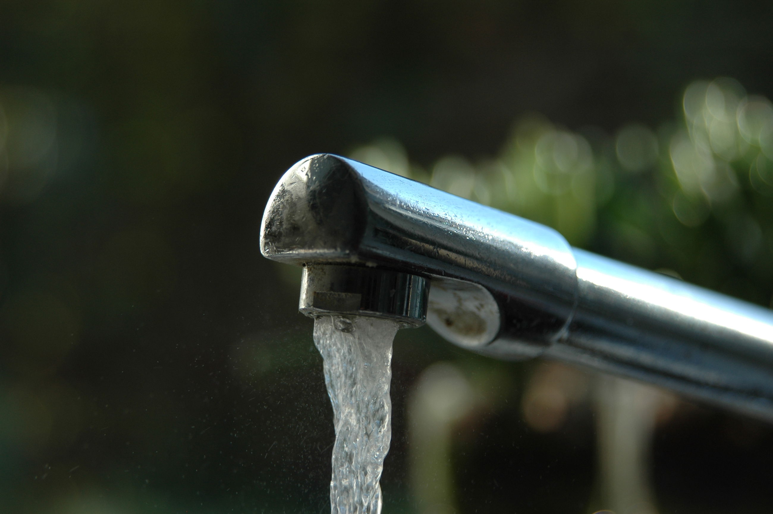 Nærbillede af vandhane som vandet løber ud af
