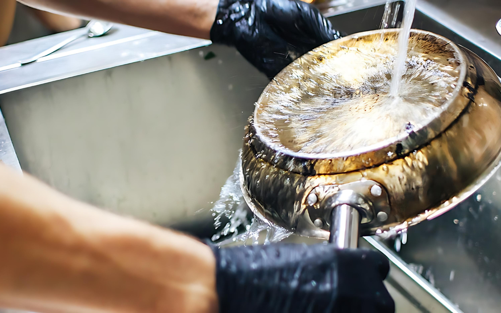Person vasker en pande under en vandhane