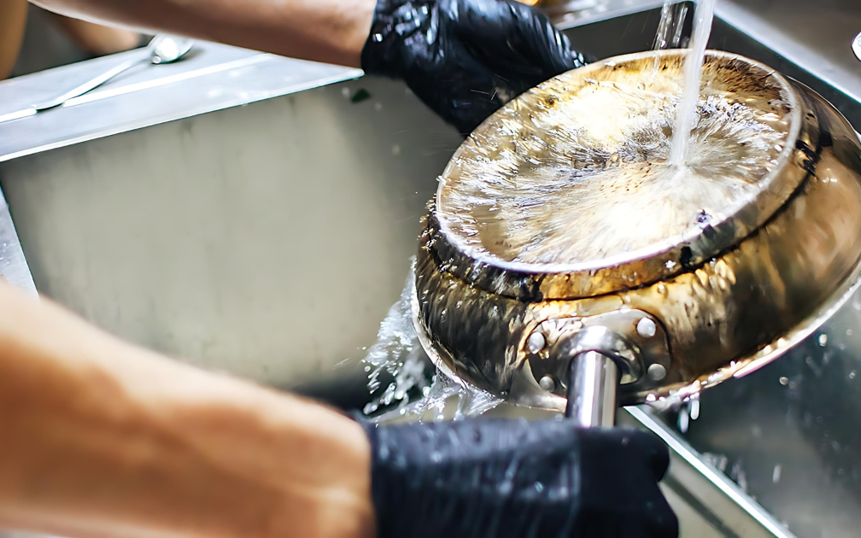 Person vasker en pande under en vandhane