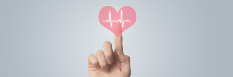 En hånd trykker på en ikon af et hjerte med hjerteslagsrytmer inden i