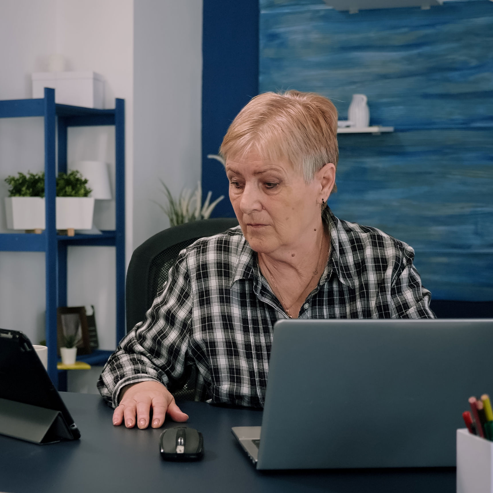 Ældre kvinde arbejder foran en computer