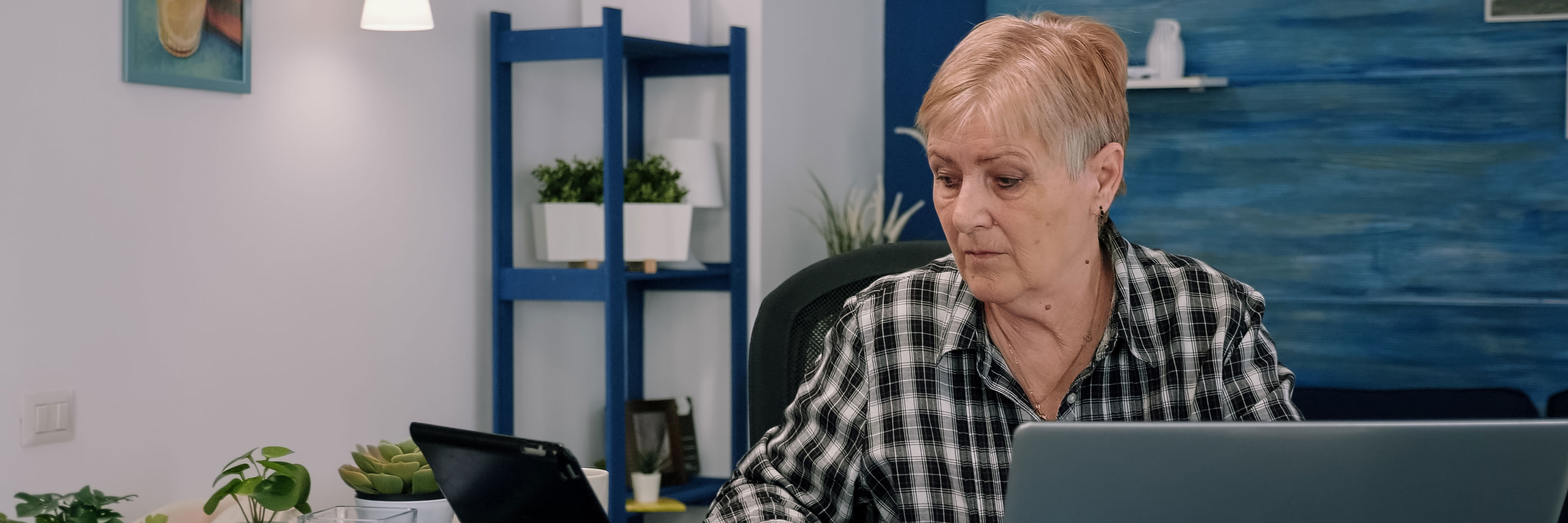 Ældre kvinde arbejder foran en computer