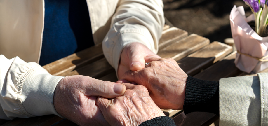 Ældre par holder hinanden i hænderne