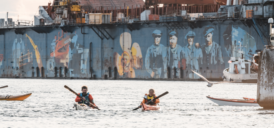 To kajakroer i Svendborg Havn med front mod kameraet og værft i baggrunden